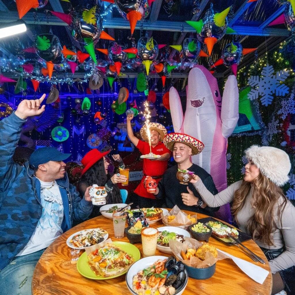 A birthday table with a sparkler cake, sombreros and confetti