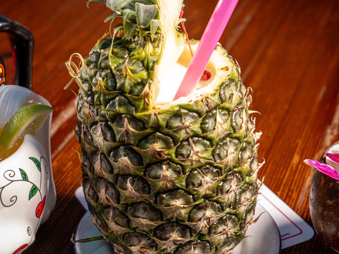 Piña Loca served in a whole pineapple with a pink straw