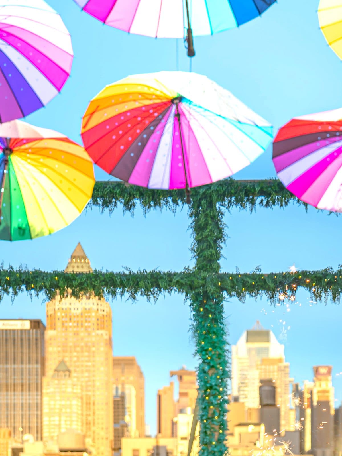 Rainbow umbrellas over the rooftop with the Midtown skyline behind
